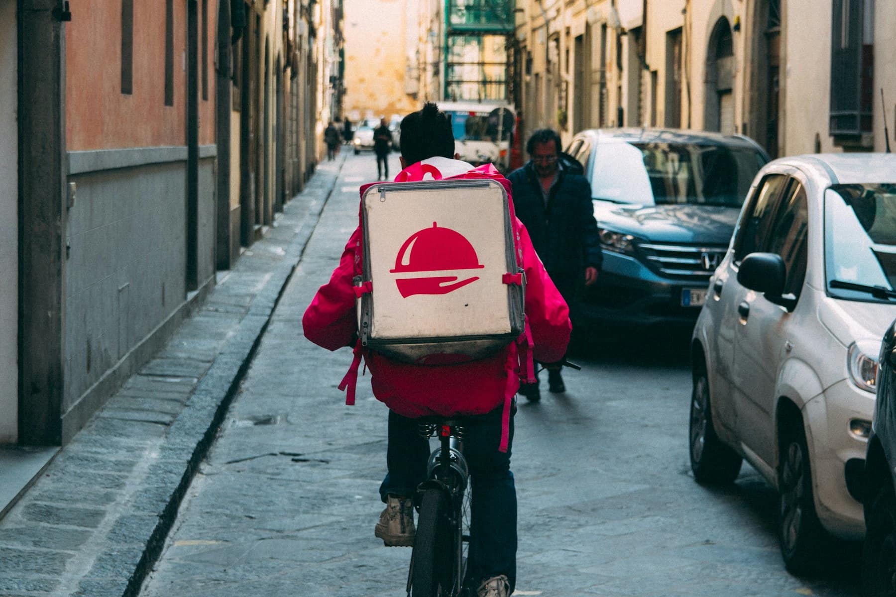 A delivery rider heading down a side street