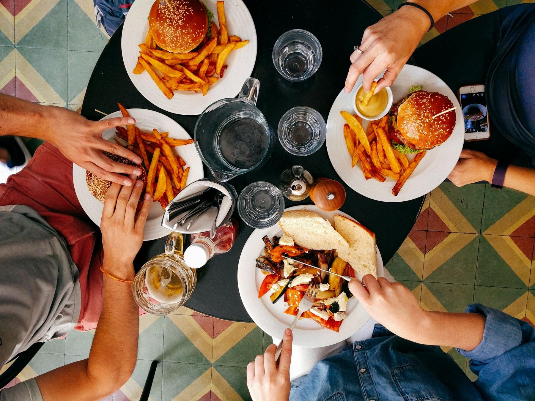 Friends sharing plates at a table, seen from above