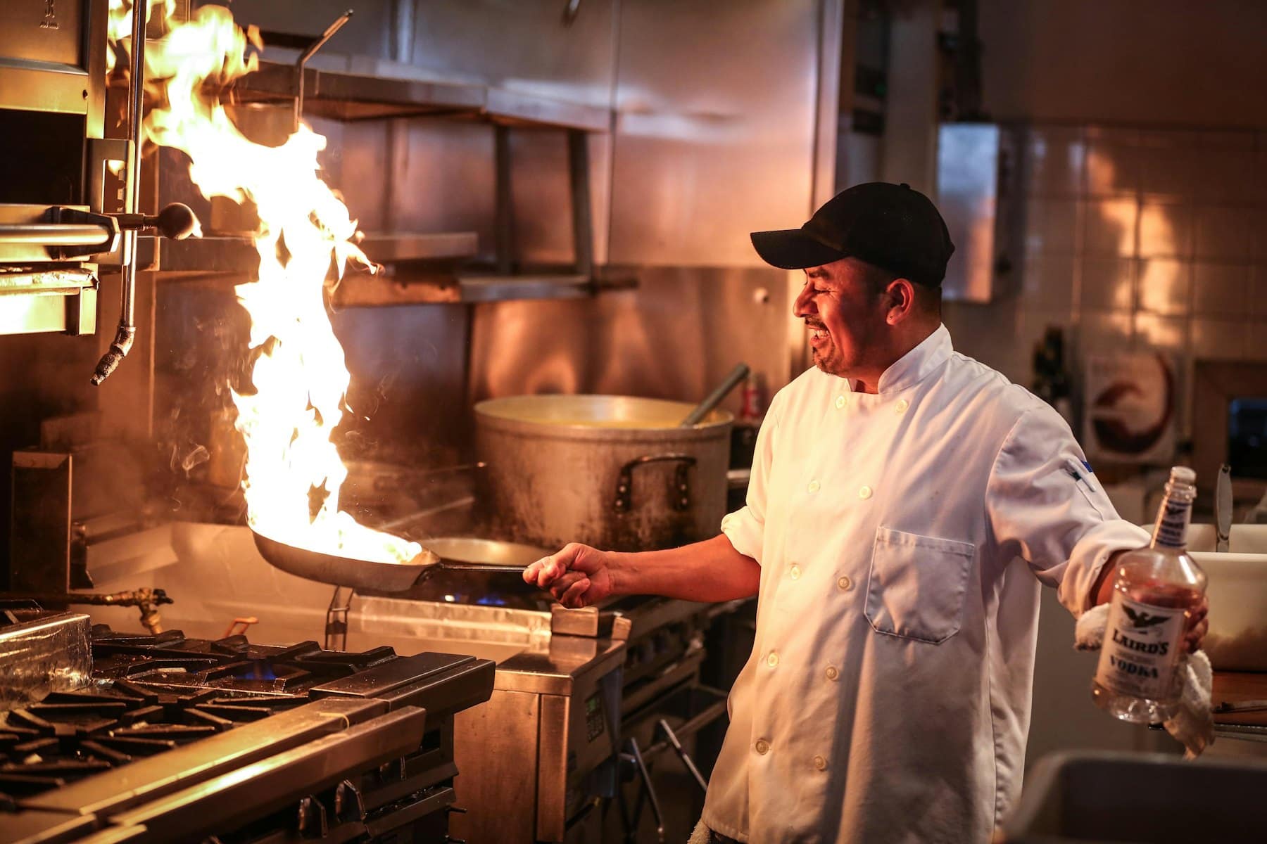 A chef working the stove in a busy kitchen